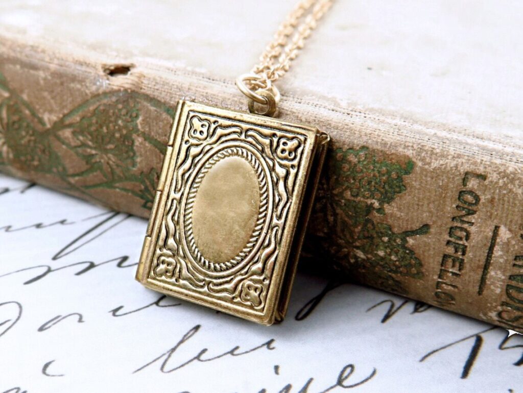 Delicate book-shaped locket necklace with a small hinged cover.