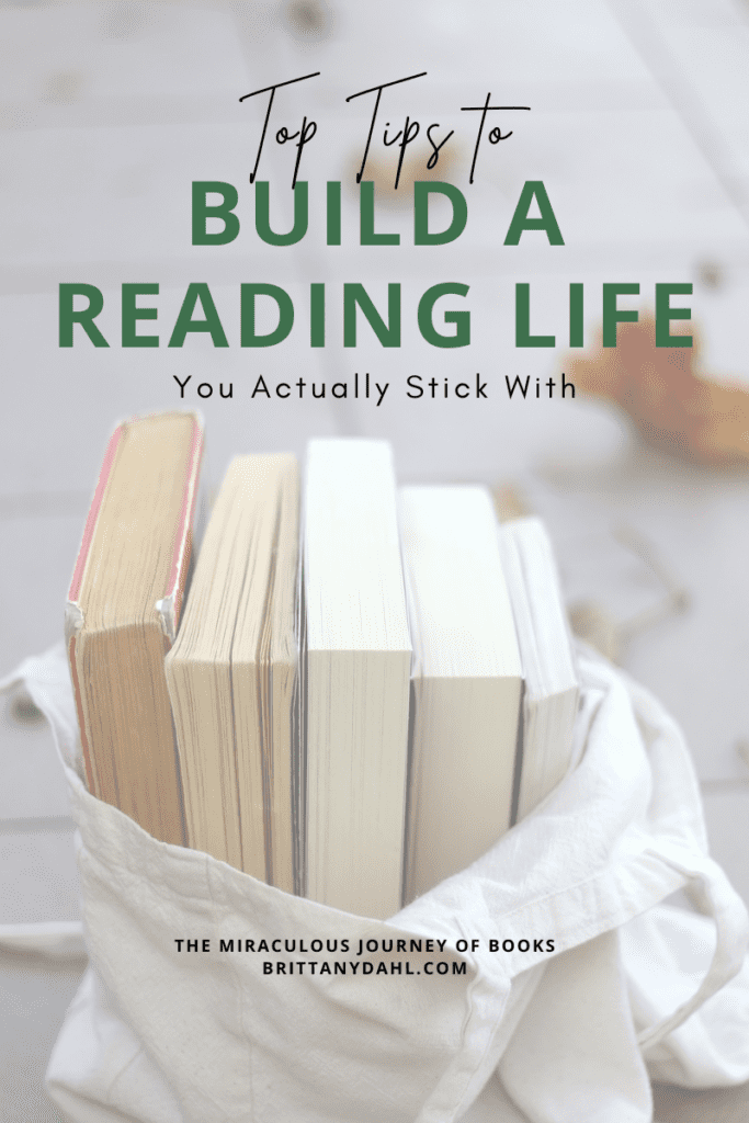 Top Tips to build a reading life you actually stick with. Image of a white bag of five books (spine facing away from camera). Blog by The Miraculous Journey of Books at BrittanyDahl.com.